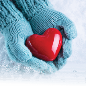 hands wearing teal blue knitted gloves, holding bright red plastic heart shape